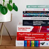 Stos książek do psychologii klinicznej studiów, w tym "Psychologia kliniczna dzieci i młodzieży" i "Psychologia sądowa", obok rośliny w doniczce.