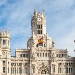 Majestatyczny budynek w Madrycie z hiszpańską flagą, idealne miejsce do studiowania iberystyki.