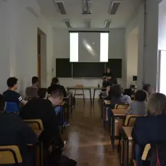 Wykład o astronomii, studenci słuchają o galaktykach.