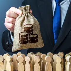 Hr manager w garniturze trzyma worek z pieniędzmi nad grupą drewnianych ludzików.