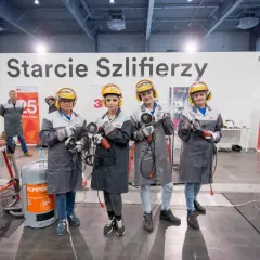 Cztery kobiety w kaskach i ochronnych okularach, gotowe do pracy jako szlifierz, trzymają szlifierki kątowe.