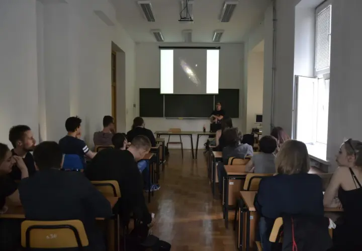 Wykład o astronomii, studenci słuchają o galaktykach.