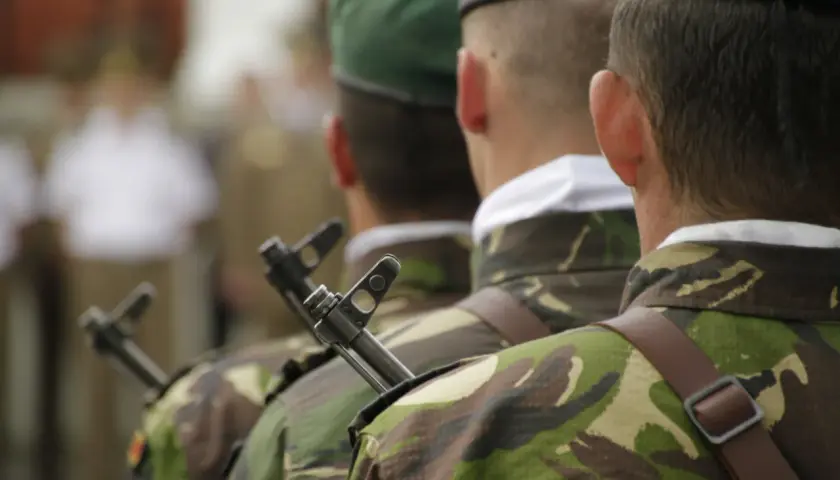 Żołnierze w mundurach i zielonych beretach, z karabinami, przygotowują się do uroczystości. To ich studia oficerskie.