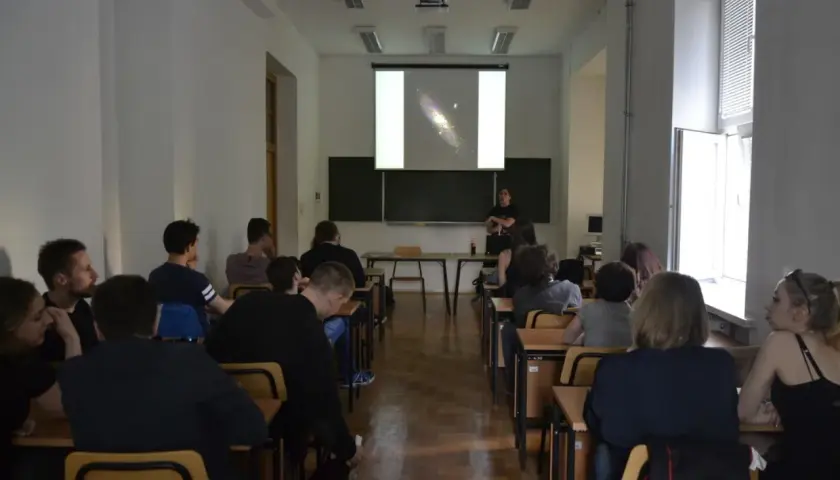 Wykład o astronomii, studenci słuchają o galaktykach.