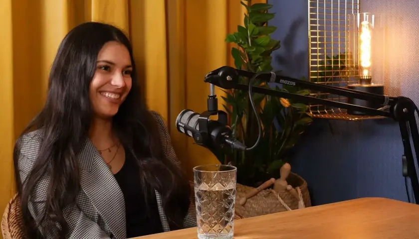 Uśmiechnięta studentka administracji podczas nagrania podcastu.
