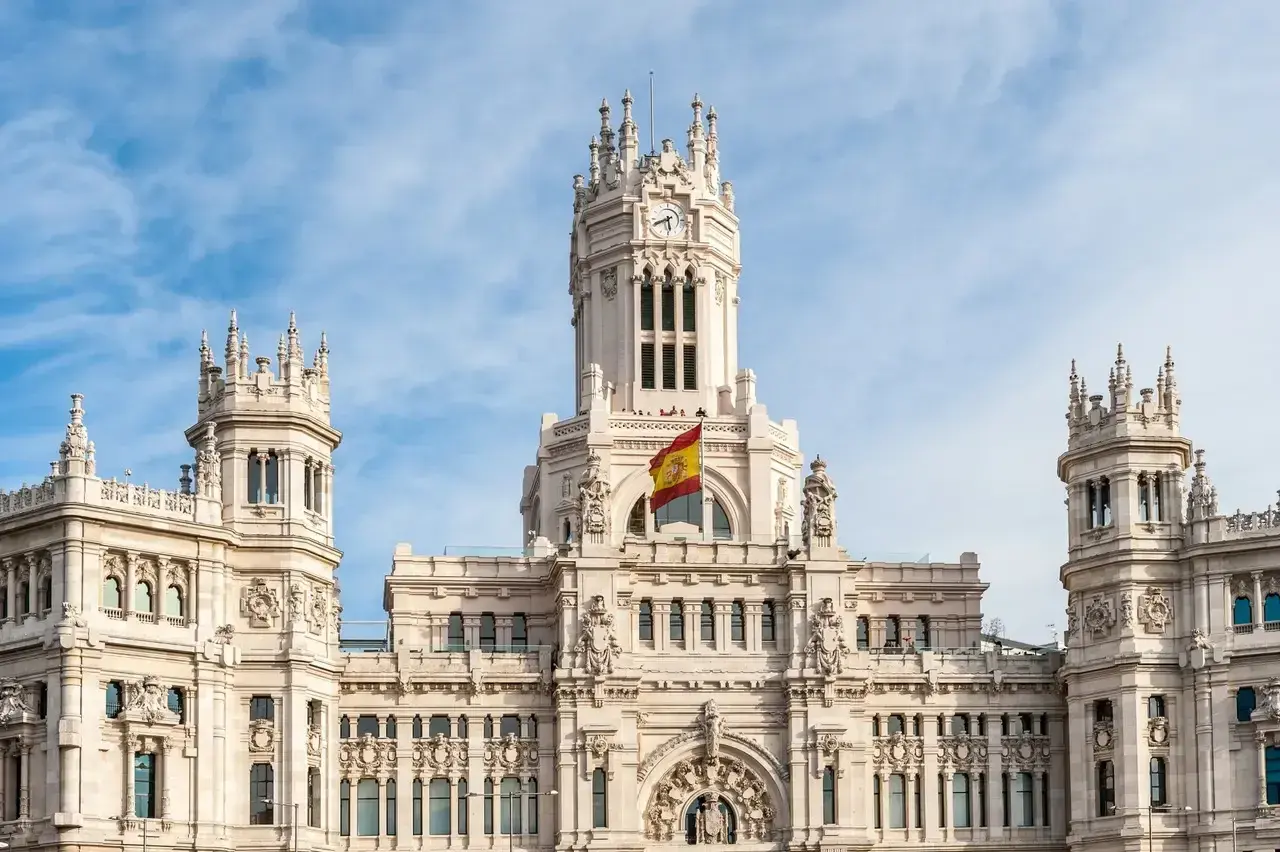 Majestatyczny budynek w Madrycie z hiszpańską flagą, idealne miejsce do studiowania iberystyki.