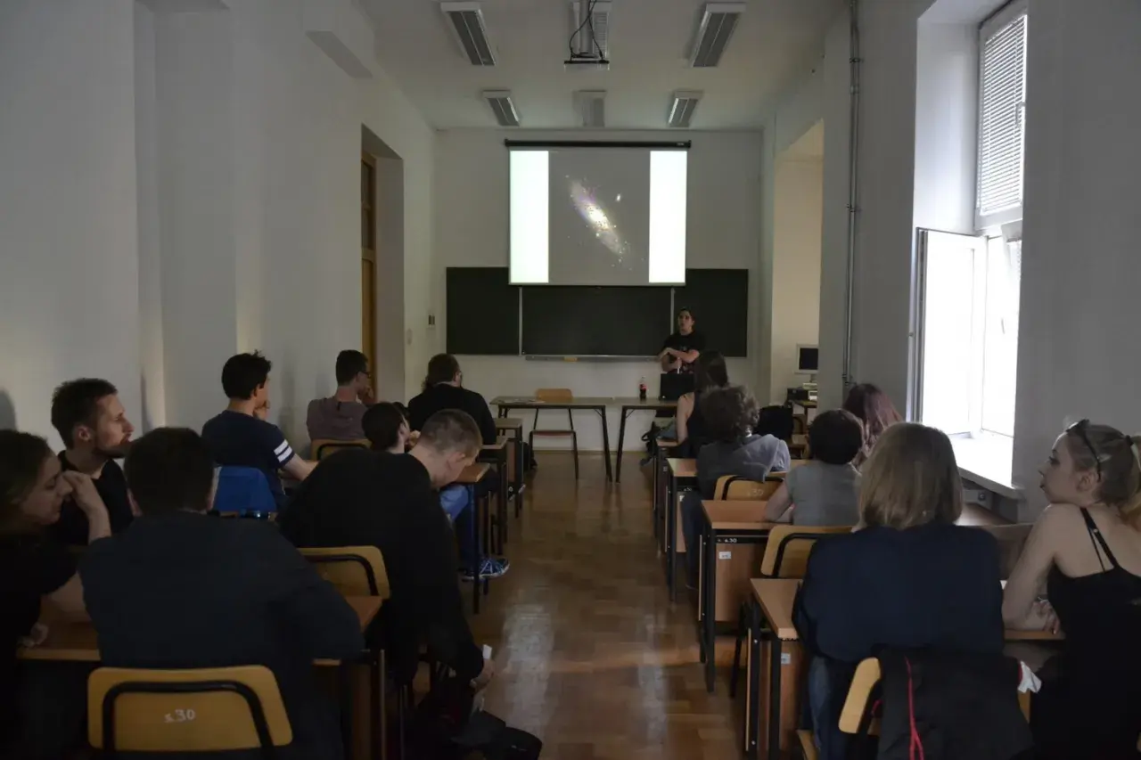 Wykład o astronomii, studenci słuchają o galaktykach.