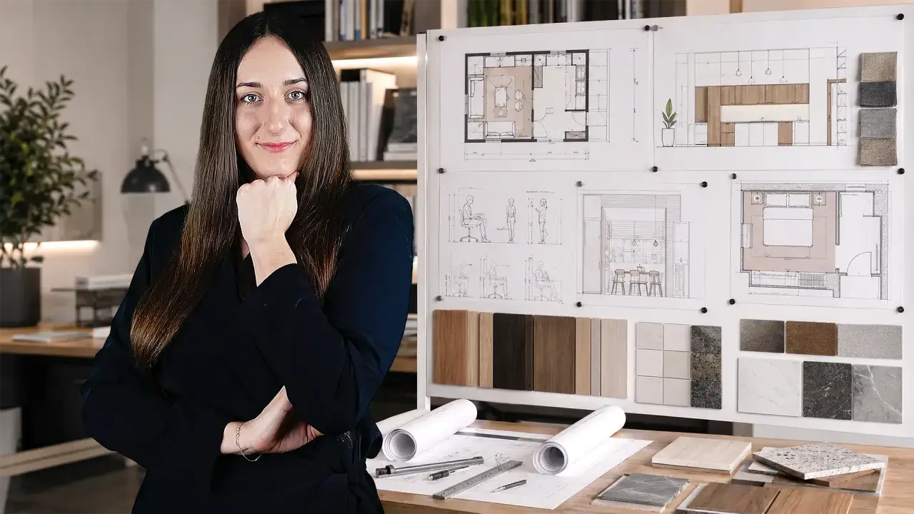 Młoda studentka architektury zamyślona nad projektami wnętrz, planszami z wizualizacjami i próbkami materiałów.