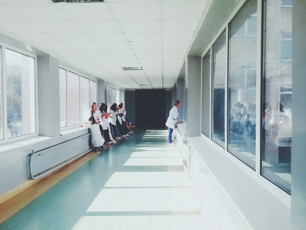 Studenci w białych fartuchach na korytarzu, szukają warszawska uczelnia medyczna im. tadeusza koźluka opinie.