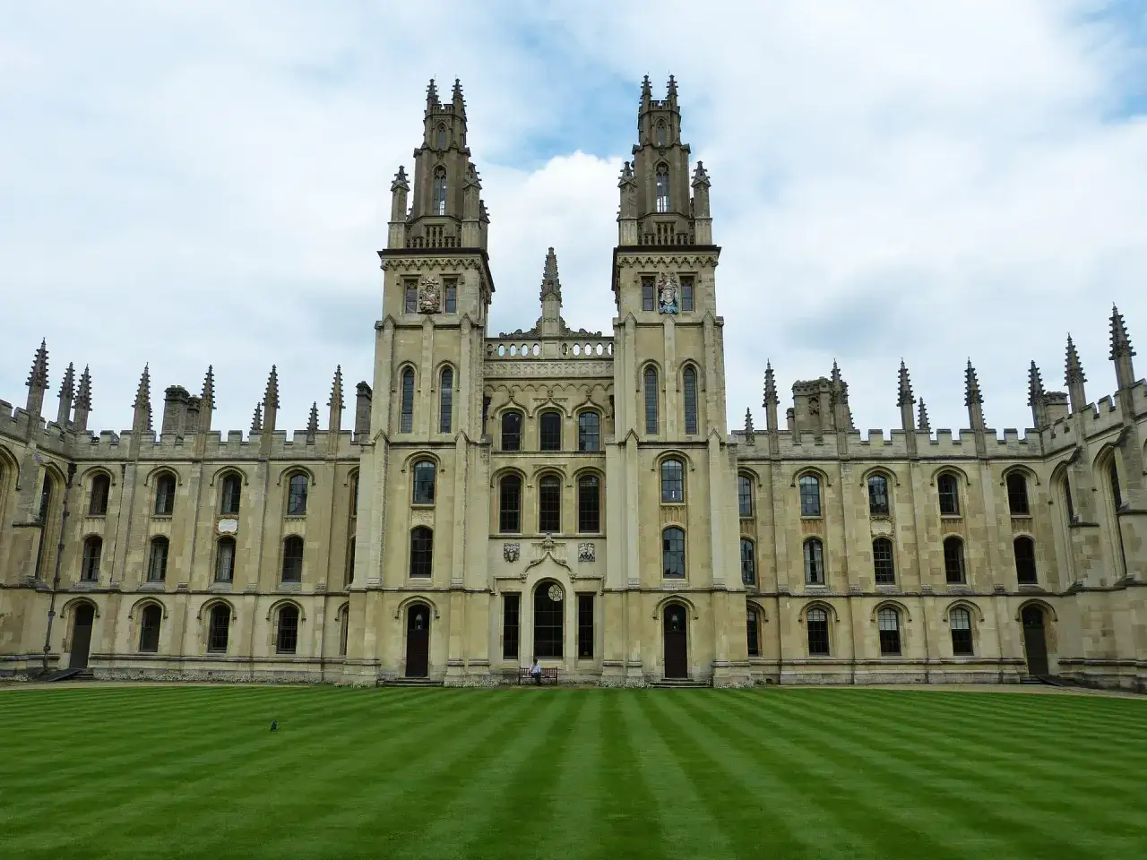 Imponująca architektura Oxford uczelnia z dwoma wieżami i zadbanym trawnikiem.