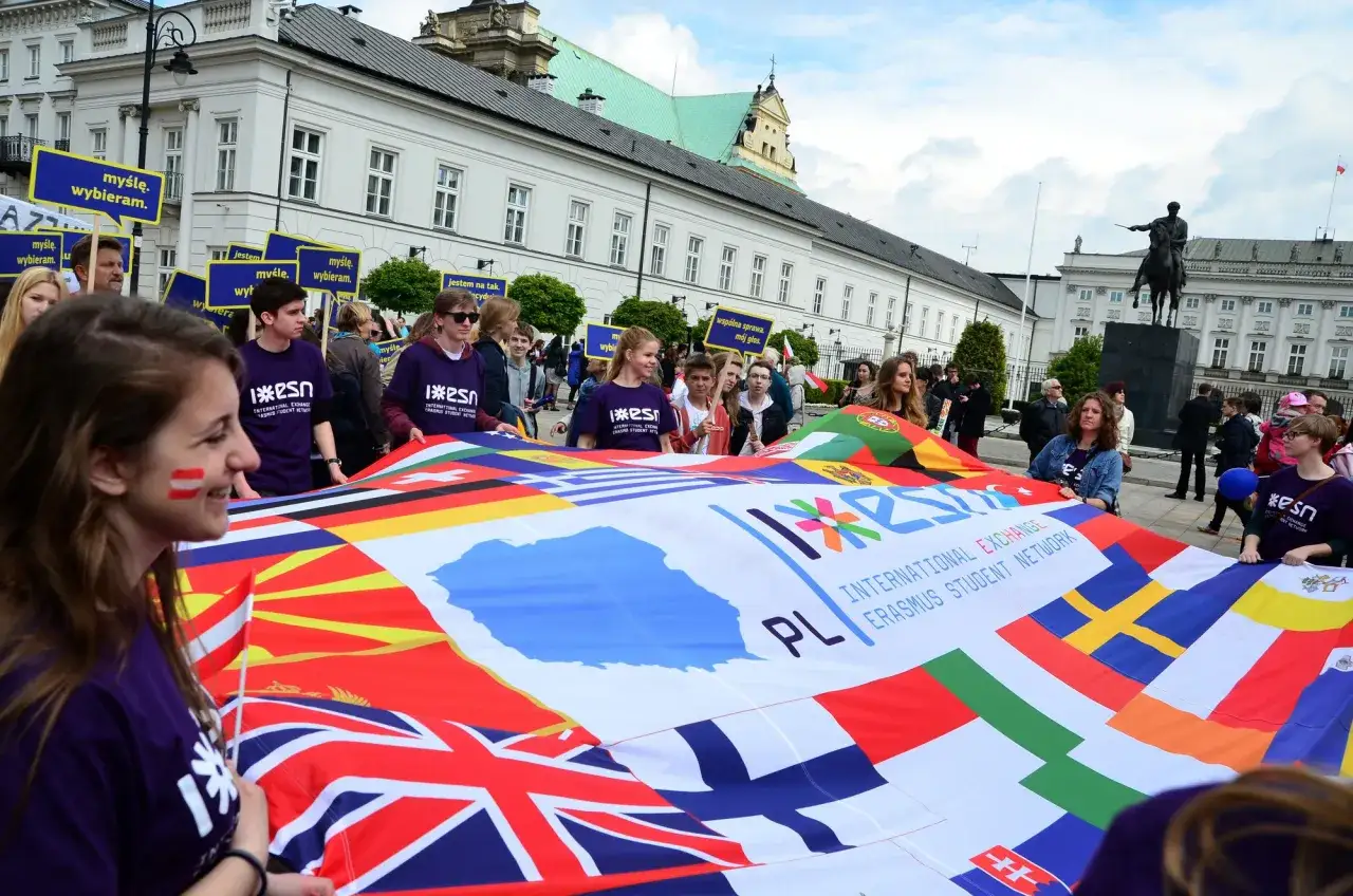 Studenci na pierwszym stopniu studiów z flagą Erasmus.