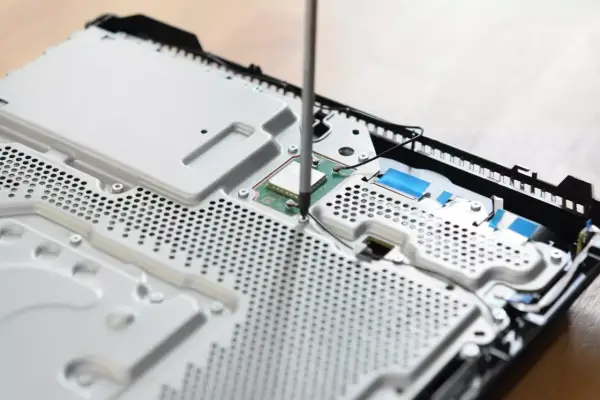 Uczeń technikum podczas praktyk zawodowych skręca konsolę.